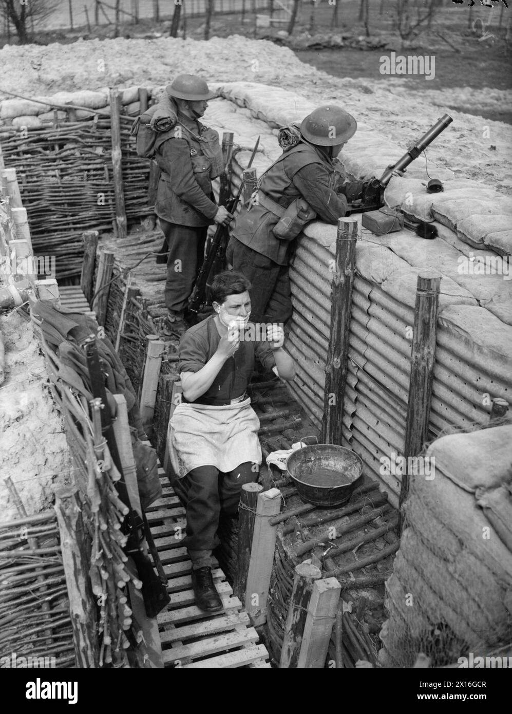 Les hommes de la compagnie d, 2nd Sherwood Foresters, 1st division, occupent une tranchée avancée près de roches le 1er avril 1940. Un soldat se rase tandis que les autres surveillent avec un mortier de 2 pouces. Banque D'Images