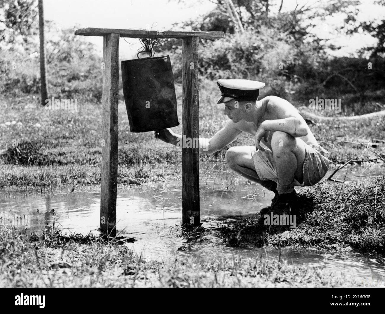 En décembre 1944, à l'HMS Rajalyia, Colombo, Ceylan, des officiers médicaux et des officiers de la Royal Navy ont été formés à la lutte contre les maladies tropicales à l'École de lutte contre le paludisme et l'hygiène. La reproduction des moustiques a été contrôlée à l'aide de barils d'huile dans les zones marécageuses. Banque D'Images