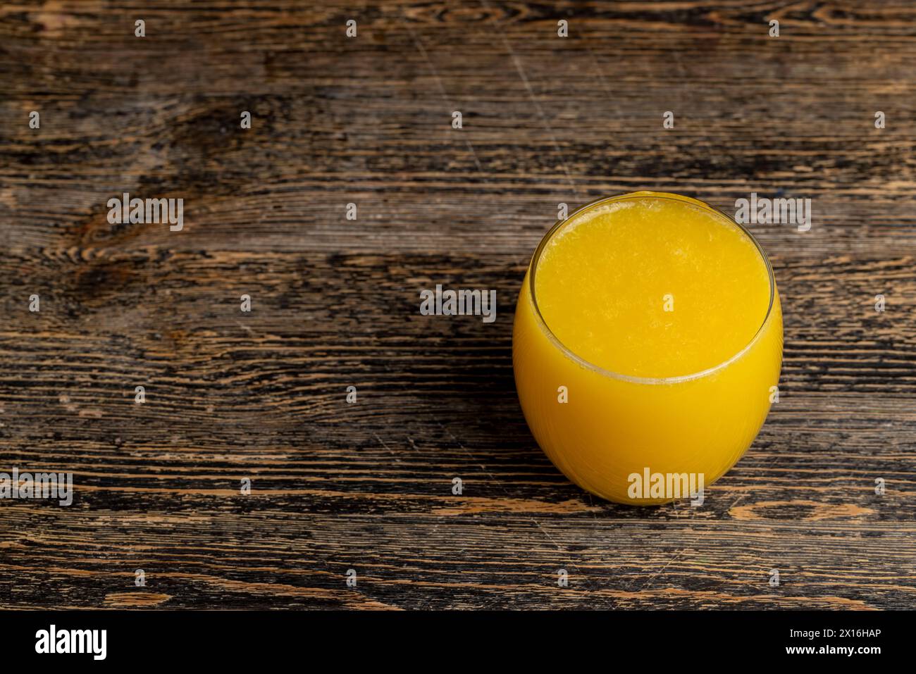 tranches d'orange pelées et jus d'orange sur la table, jus d'orange dans une tasse en verre gros plan Banque D'Images