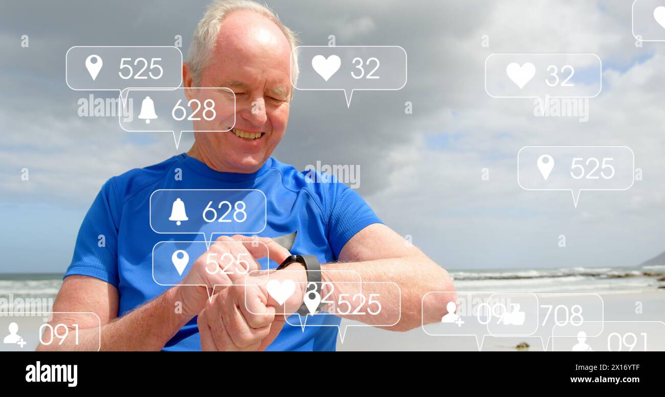 Image de barres de notification sur un homme caucasien senior utilisant smartwatch à la plage Banque D'Images