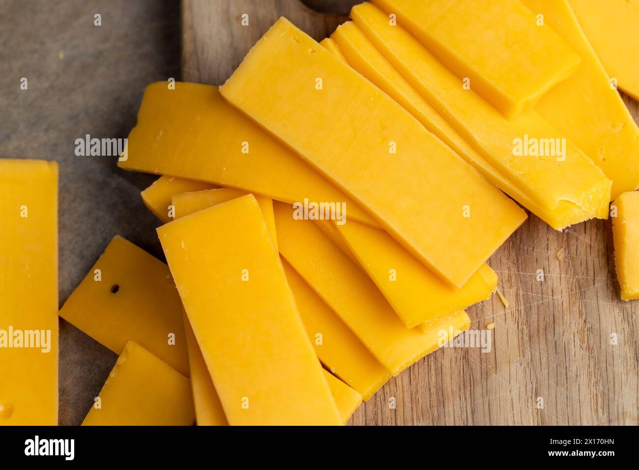 un morceau de fromage jaune sur la planche, fromage à pâte dure fait de lait sur la table Banque D'Images