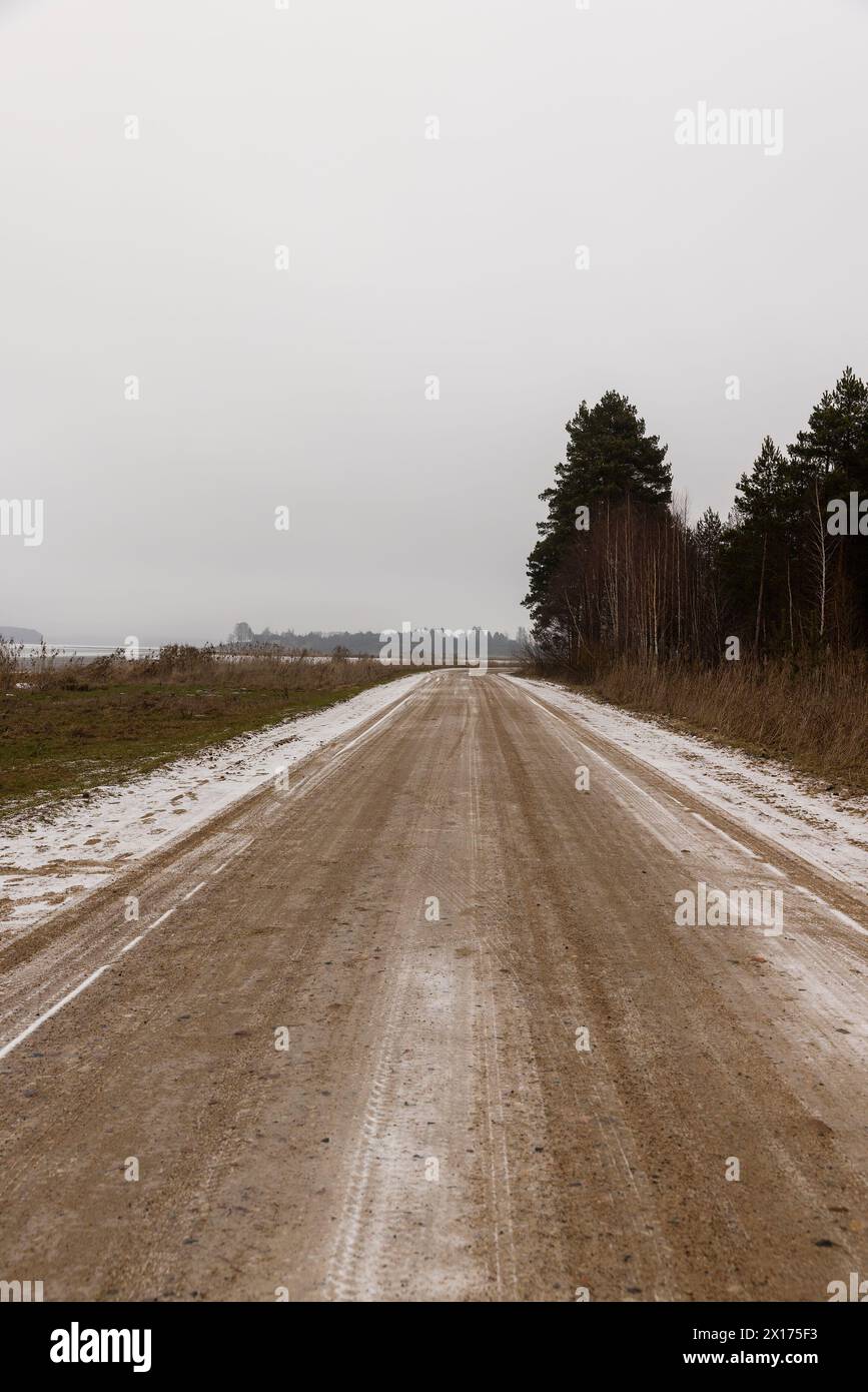 route de gravier dans la campagne en hiver, autoroute glissante enneigée en hiver Banque D'Images