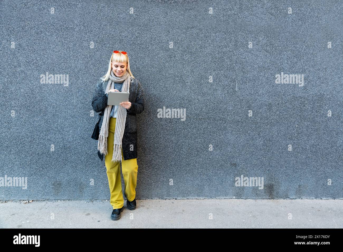 Portrait de jeune femme indépendante à la mode confiante avec une attitude cool travaillant sur tablette numérique à l'extérieur de l'immeuble de bureaux. Hipster élégant femme p Banque D'Images
