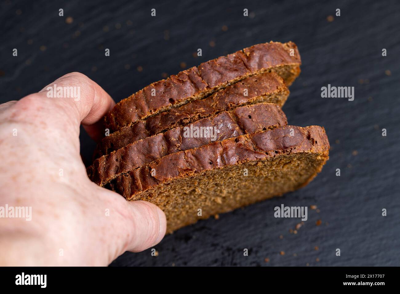 pain noir tranché sur une planche d'ardoise noire, morceaux carrés de pain frais Banque D'Images