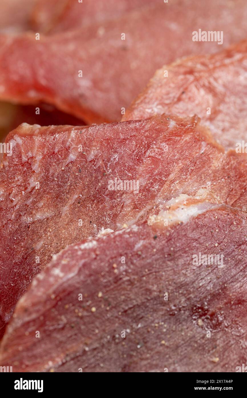 viande séchée sur papier en gros plan, morceaux de porc séché avec épices et sel sur papier froissé Banque D'Images