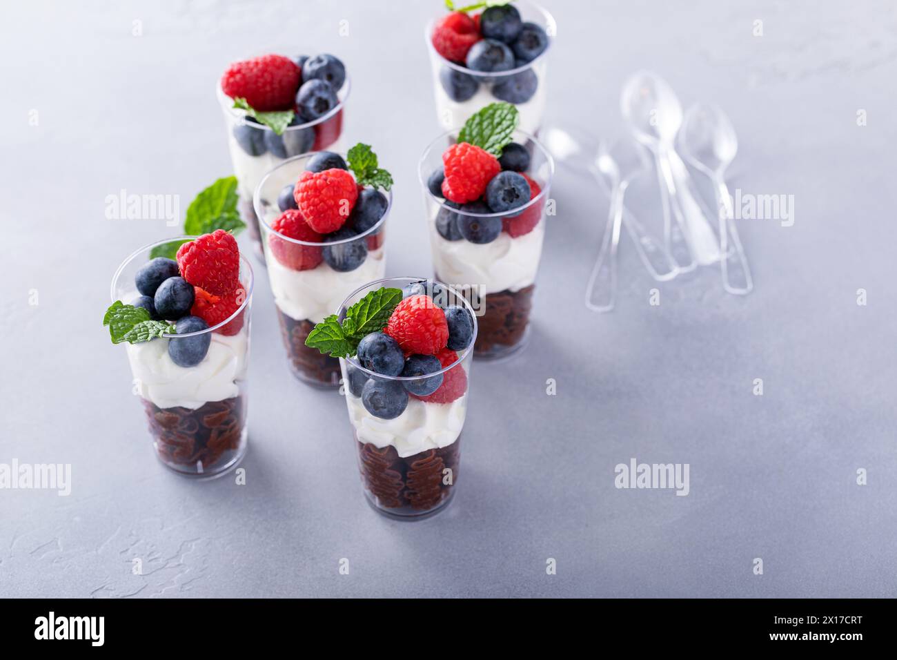 Mousse au chocolat dans des tasses garnie de crème fouettée et de baies fraîches Banque D'Images