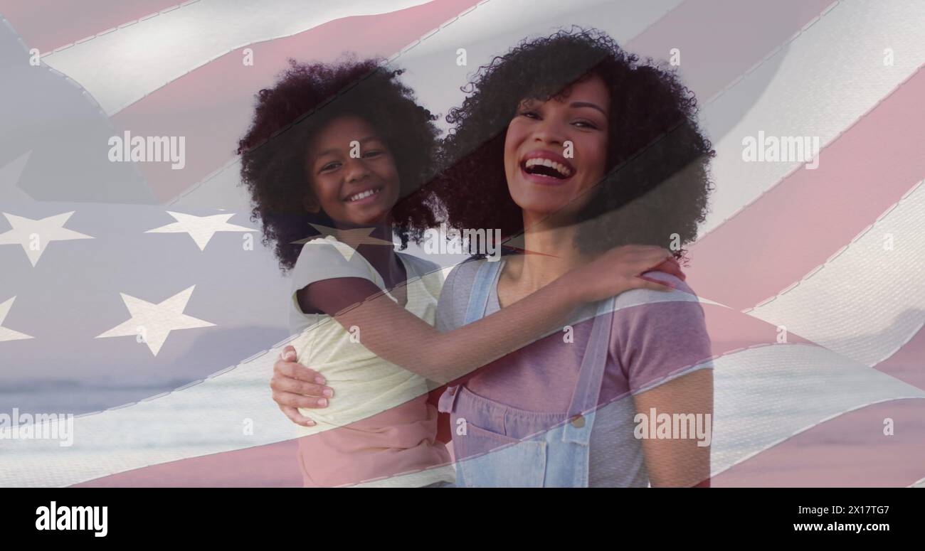 Image composite du drapeau américain sur la mère afro-américaine et sa fille souriant à la plage Banque D'Images