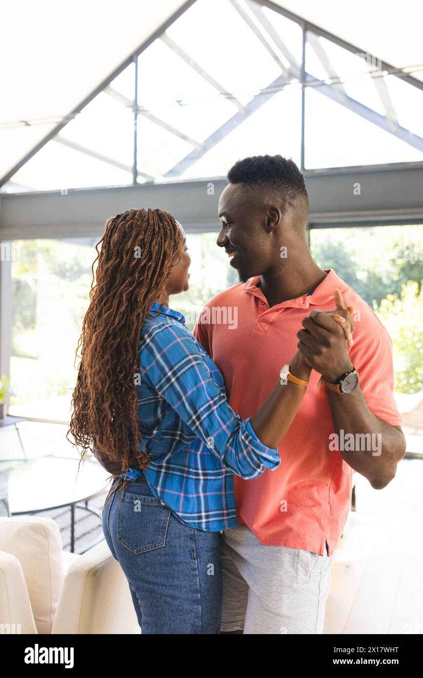 Couple afro-américain se tenant la main, se regardant amoureusement à la maison Banque D'Images