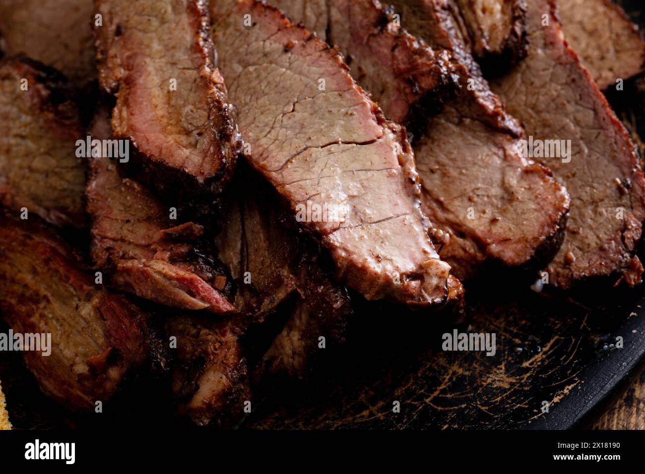 Poitrine de boeuf fumé tranchée sur l'assiette de service avec pain grillé et sauce barbecue Banque D'Images