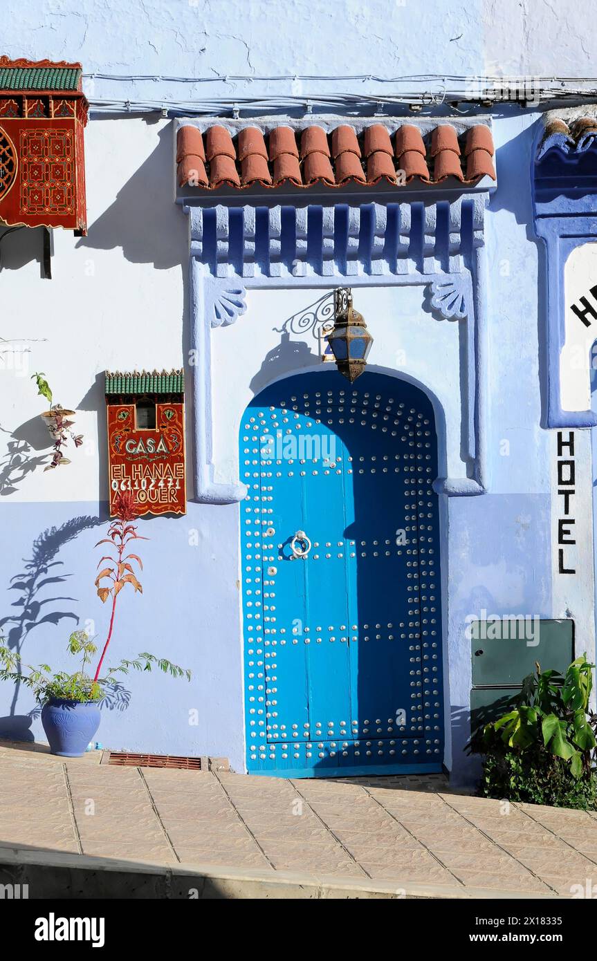 Chefchaouen, portes bleues traditionnelles dans un mur bleu avec des motifs nord-africains et des pots de fleurs, Chefchaouen, Maroc Banque D'Images