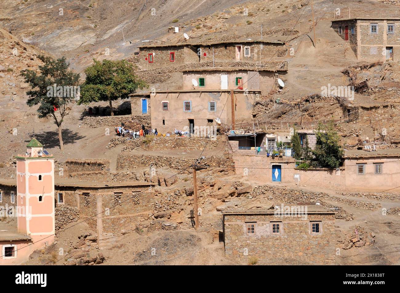 Les maisons de village avec volets colorés sont construites à flanc de montagne, Sud du Haut Atlas, Maroc Banque D'Images