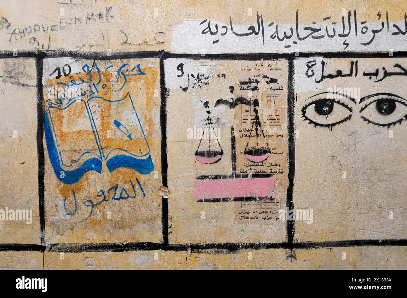 Fès, Street art avec des caractères arabes et une paire d'yeux sur un mur jaune, Nord du Maroc, Maroc Banque D'Images