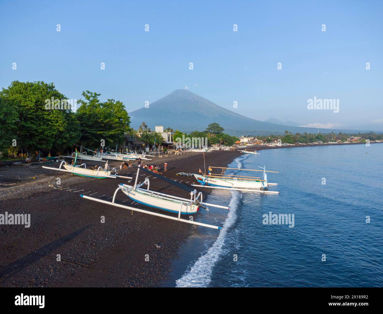 Les pêcheurs déchargent leurs prises de leur bateau-balancier le matin, en arrière-plan Gunung Agung, Amed, Karangasem, Bali, Indonésie Banque D'Images