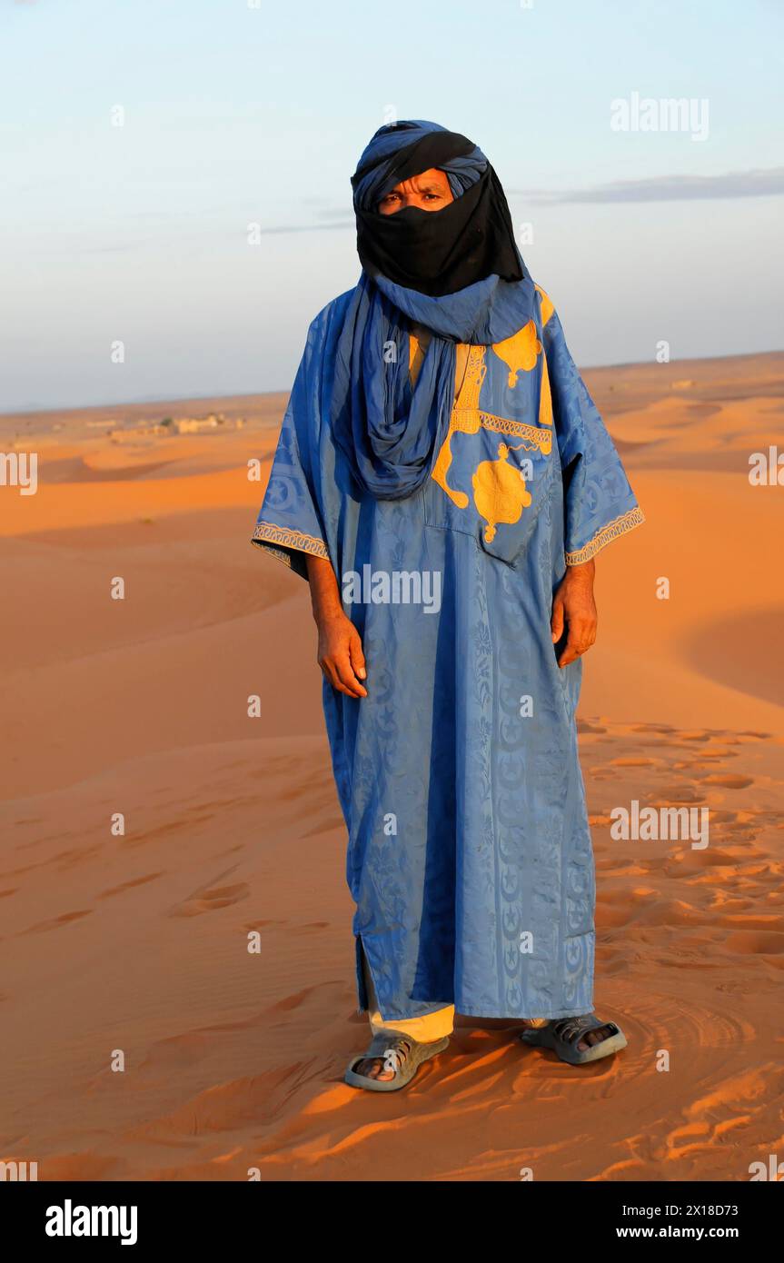 Personne en vêtements traditionnels touareg debout sur une dune de sable dans le désert, moyen Atlas, Maroc Banque D'Images