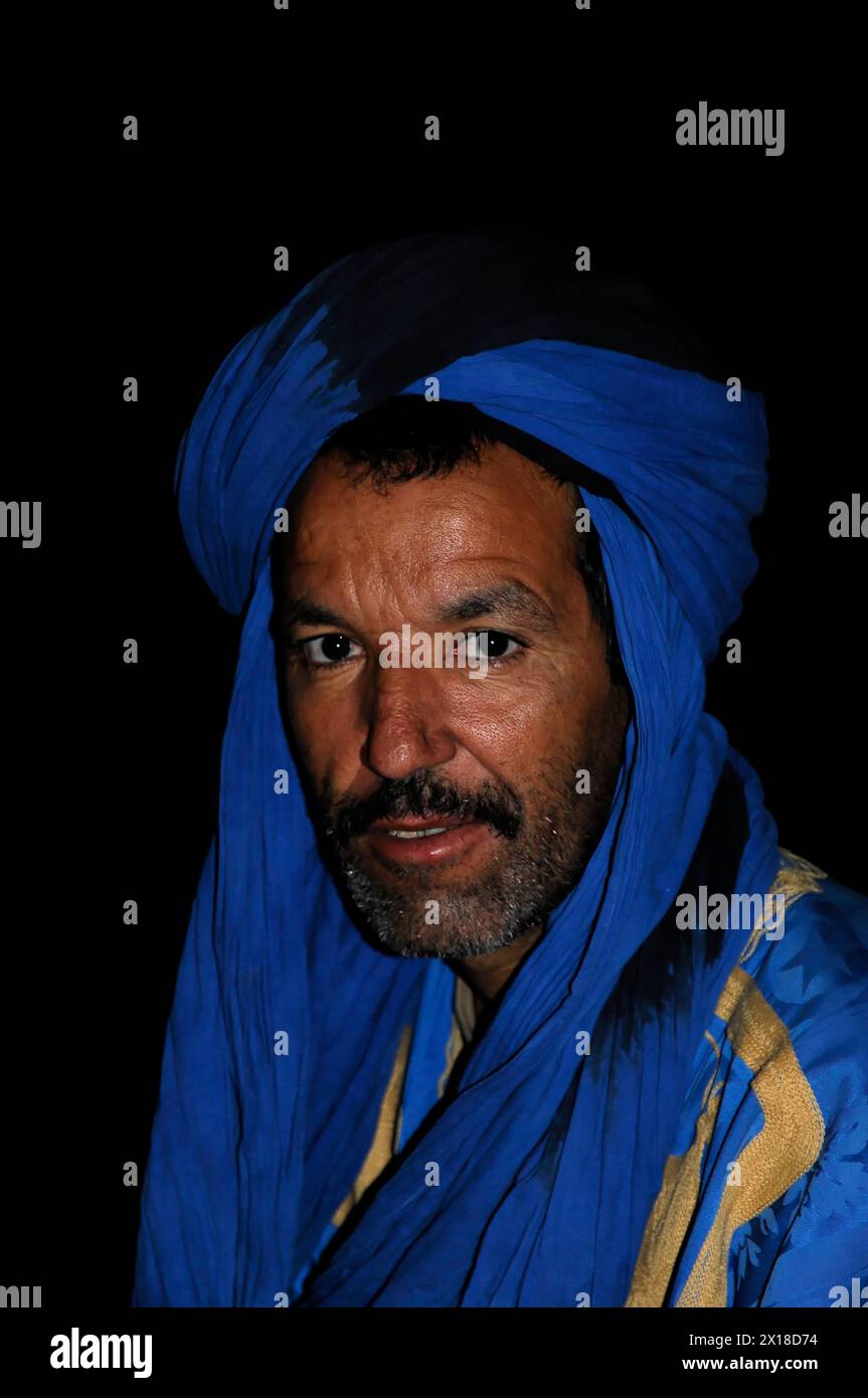 Près d'Erfoud, Portrait d'un homme avec un turban bleu et un regard sérieux, moyen Atlas, Maroc Banque D'Images