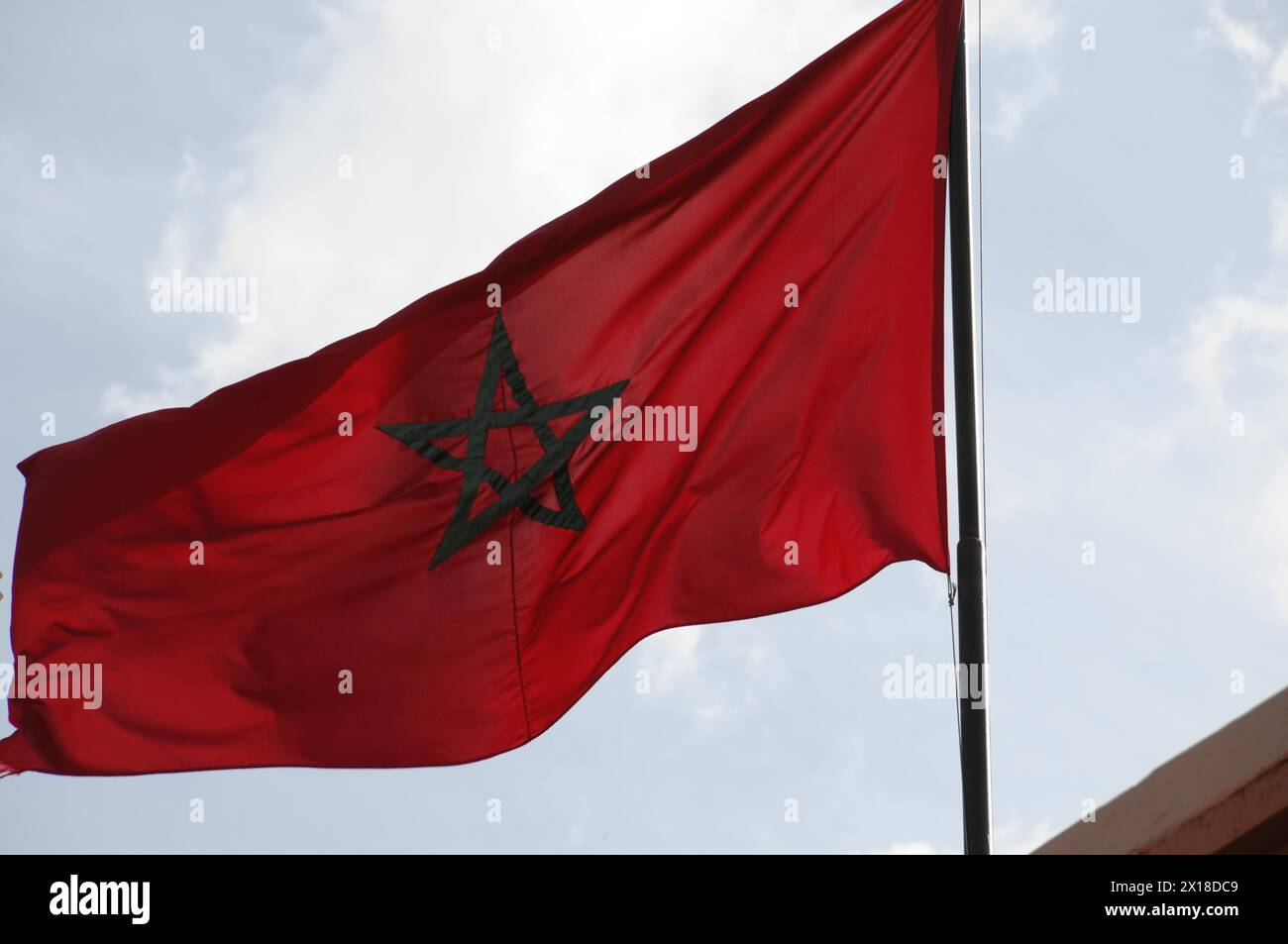 Marrakech, le drapeau rouge marocain avec une étoile verte vole dans le vent contre un ciel bleu, Marrakech, Maroc Banque D'Images