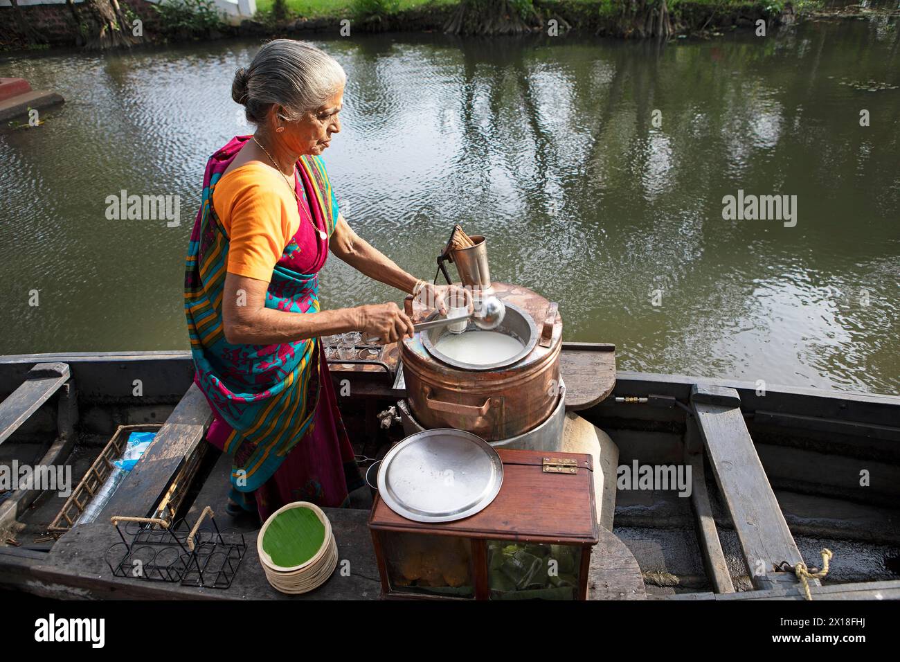 Tealady, 83 ans, bouteilles de thé indien, backwaters, Kumarakom, Kerala, Inde Banque D'Images