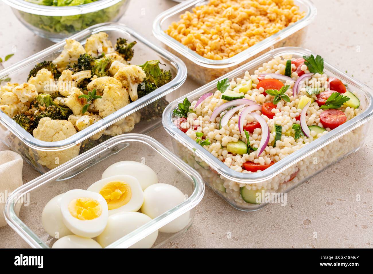Préparation de repas végétariens sains avec œufs durs, légumes rôtis, lentilles cuites, salade de couscous et noix mélangées Banque D'Images