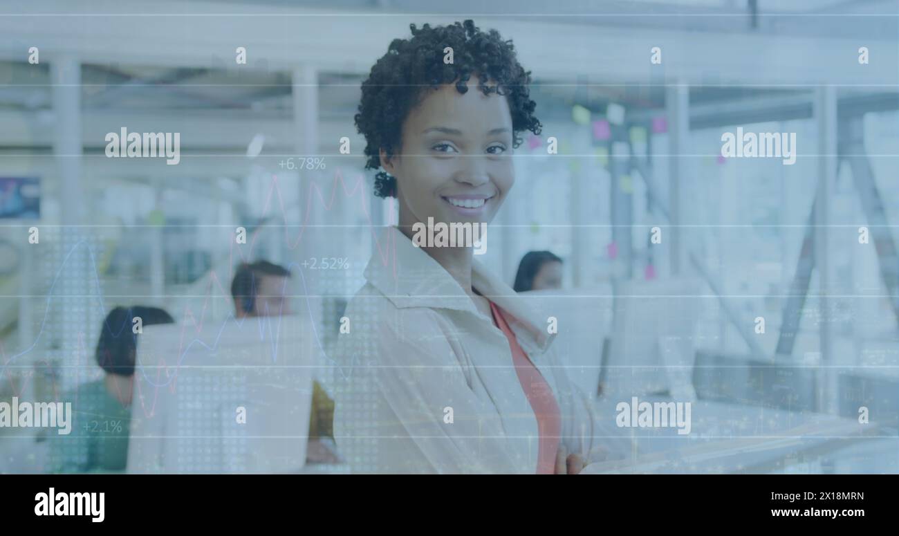 Image du traitement des données financières au-dessus de la femme d'affaires biraciale dans le bureau Banque D'Images