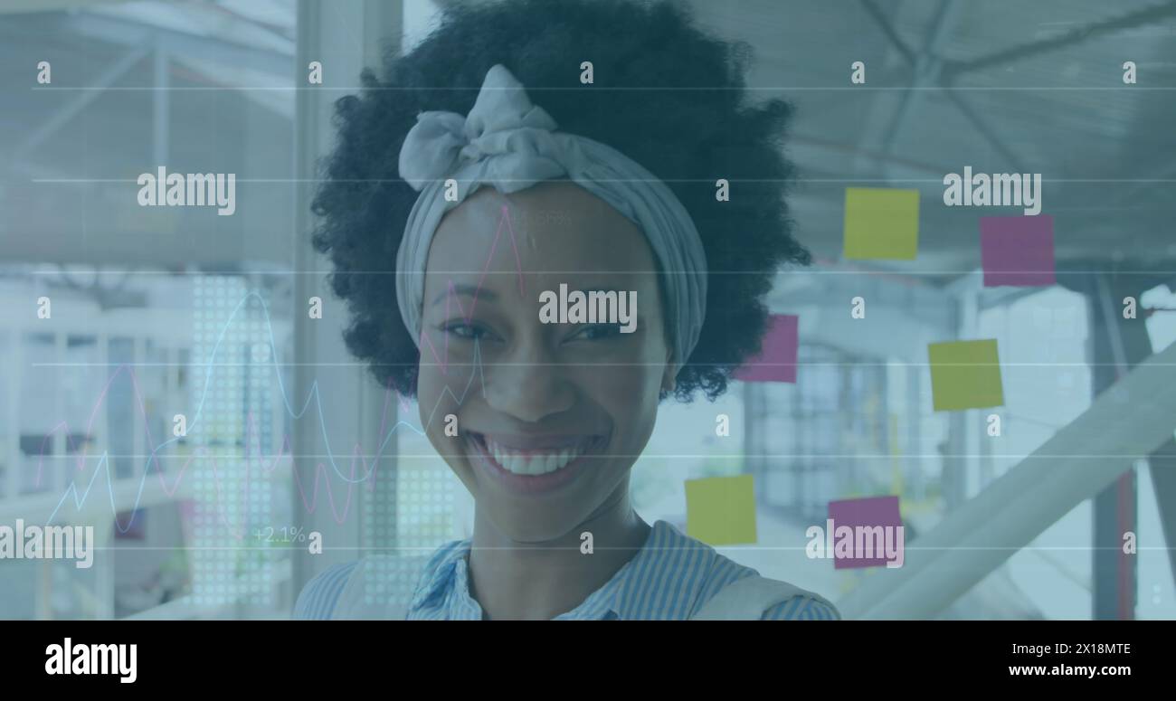 Image du traitement des données financières au-dessus de la femme d'affaires biraciale dans le bureau Banque D'Images