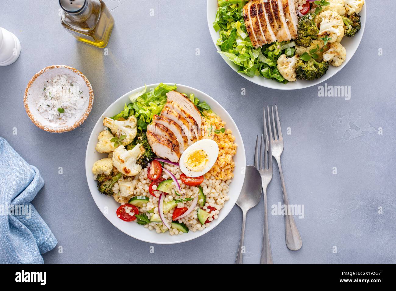 Bol à lunch sain avec poulet grillé, légumes rôtis, laitue fraîche, lentilles cuites, salade de couscous et œuf dur Banque D'Images