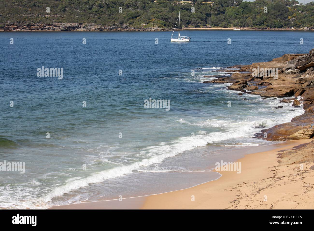 Côte du port de Sydney, plage de Cobblers sur Middle Head avec voile en yacht passé, vue depuis la plage de Wshaway sur Dobroyd Head, Sydney, Australie Banque D'Images