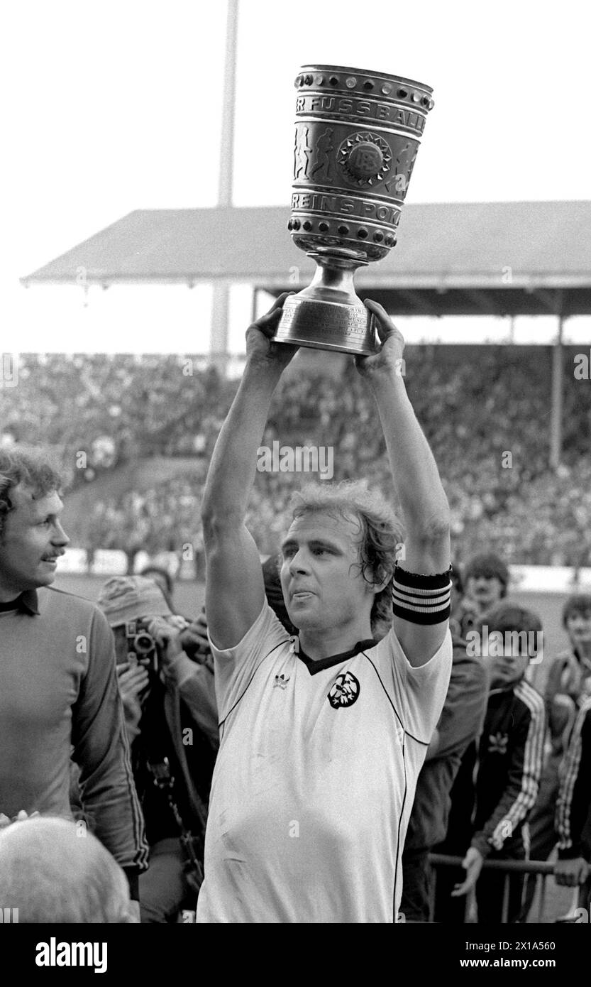 CLASSÉ - 02 mai 1981, Bade-Württemberg, Stuttgart : L'attaquant et capitaine de l'Eintracht Francfort Bernd Hölzenbein (au centre) lève triomphalement la DFB Cup aux côtés du gardien de but Jürgen Pahl (à gauche). L'Eintracht Francfort a remporté la finale de la DFB Cup contre 1. FC Kaiserslautern 3:1 devant 71 000 spectateurs au Neckarstadion de Stuttgart, sécurisant la coupe pour la troisième fois. Hölzenbein meurt à l'âge de 78 ans. Photo : Picture alliance/dpa Banque D'Images