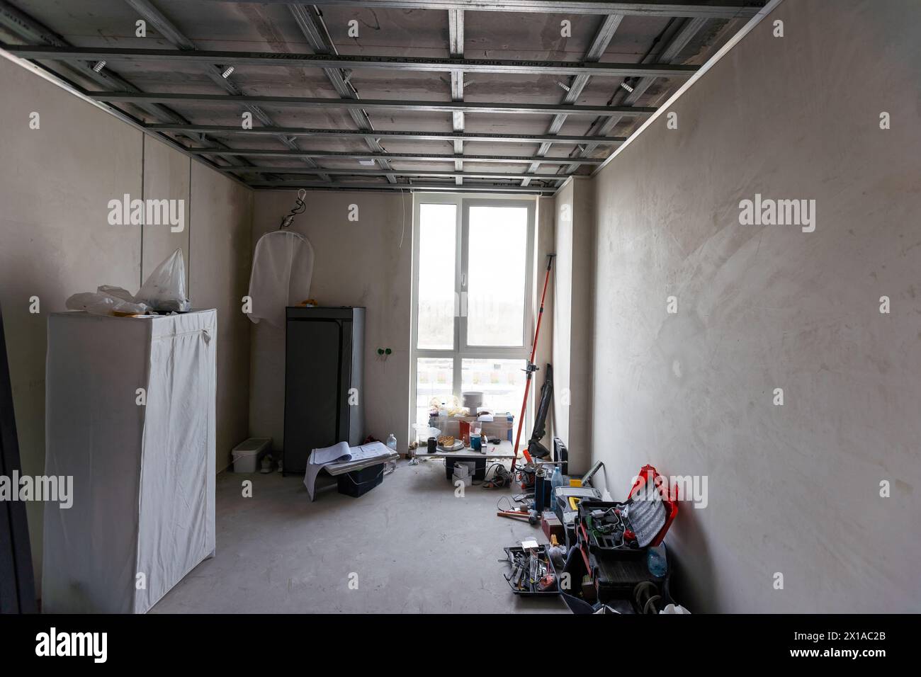 Les travailleurs installent des plaques de plâtre (cloisons sèches) pour les murs de gypse dans l'appartement est en construction, remodelage, rénovation, extension, restauration et Banque D'Images