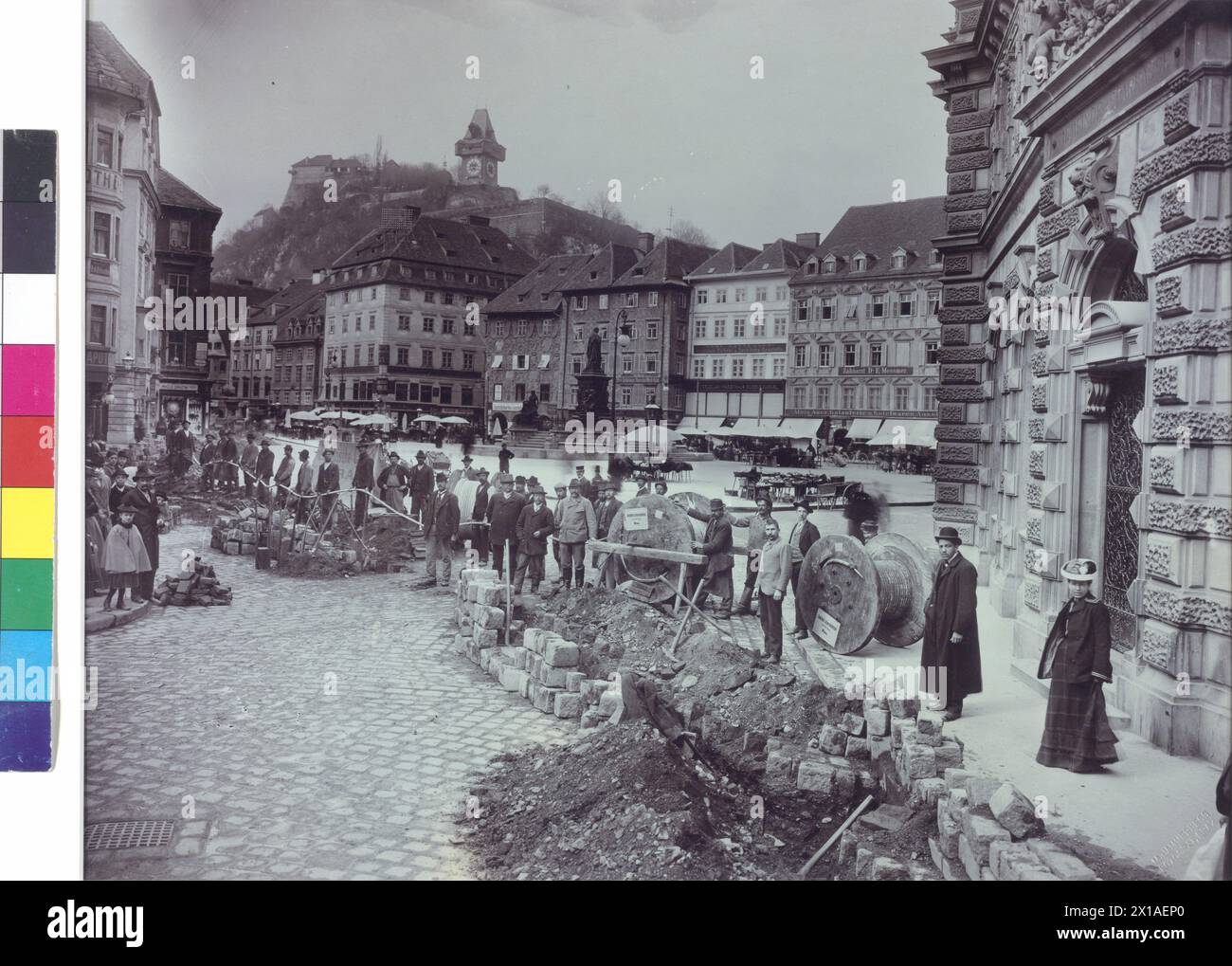 Rénovations sur la place principale de Graz, ouvrier et spectateur le long du pavé perforé pour la pose du câble sur la place principale avec tour de l'horloge, timbre aveugle, titre au passe-partout historique, 17.03.1903 - 19030317 PD0001 - Rechteinfo : droits gérés (RM) Banque D'Images