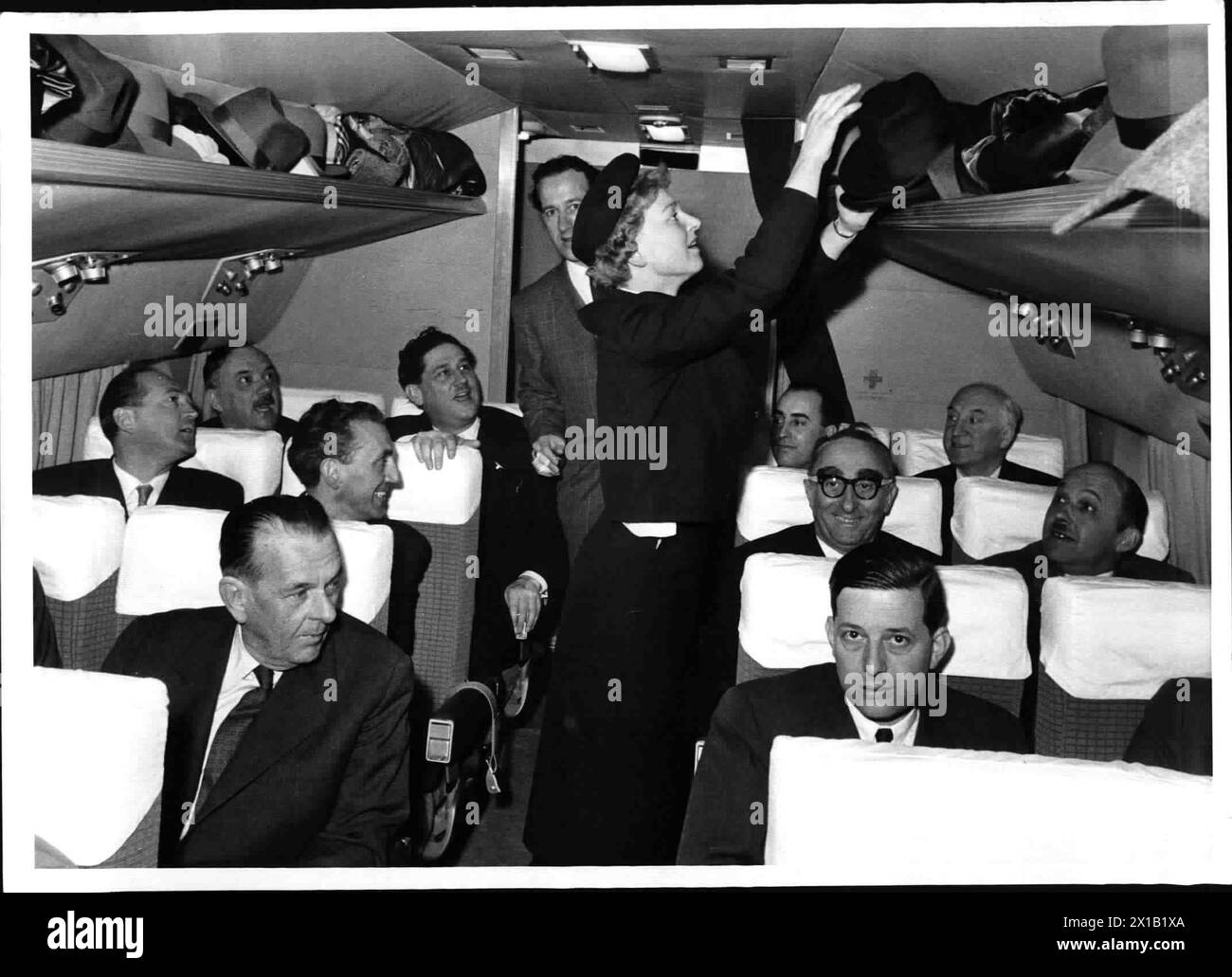 Premier vol Austrian Airlines pour Londres, cabine passagers : ministre fédéral Waldbrunner, Conseil National Polcar, vice-maire vignoble, directeur général Drimml, hôtesse de l'air pendant le rangement des bagages, 1958 - 19580101 PD2540 - Rechteinfo : droits gérés (RM) Banque D'Images