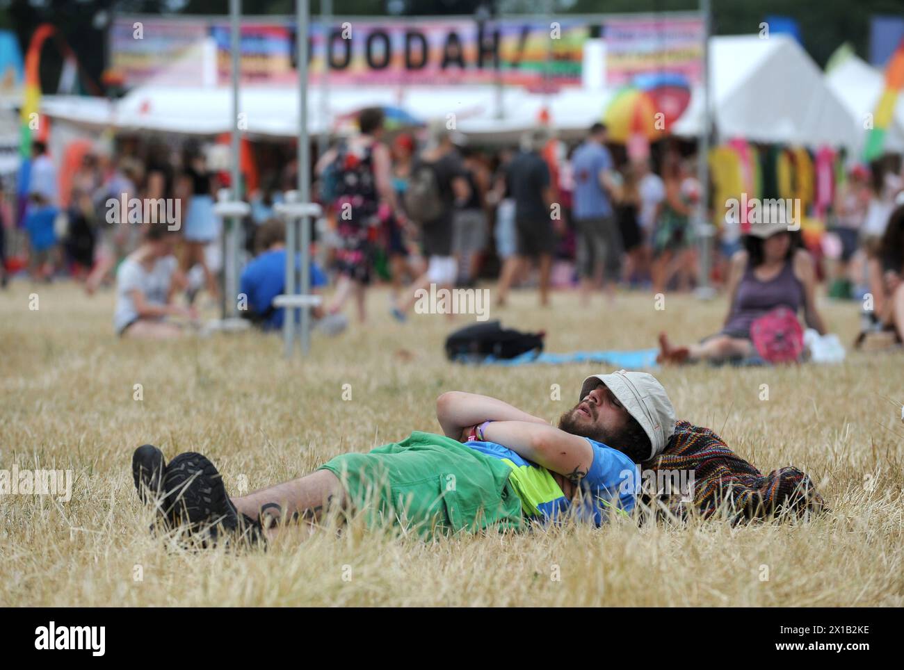 Un homme se détend au soleil pendant le festival WOMAD 2013, qui se tient à Charlton Park, Wiltshire. Banque D'Images