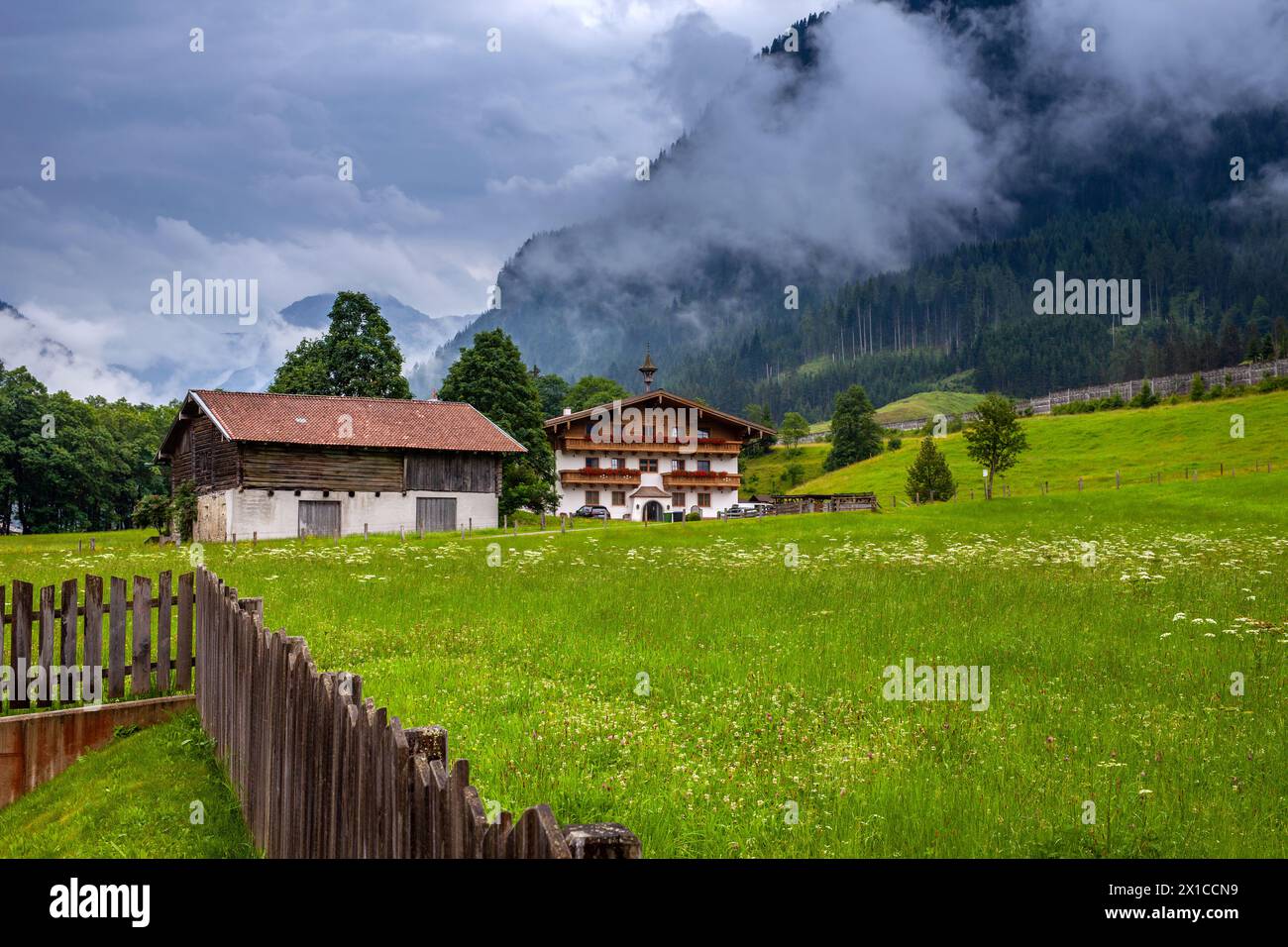 Grange rustique et chalet alpin à Flachau brumeux, Autriche, scène pastorale. Banque D'Images