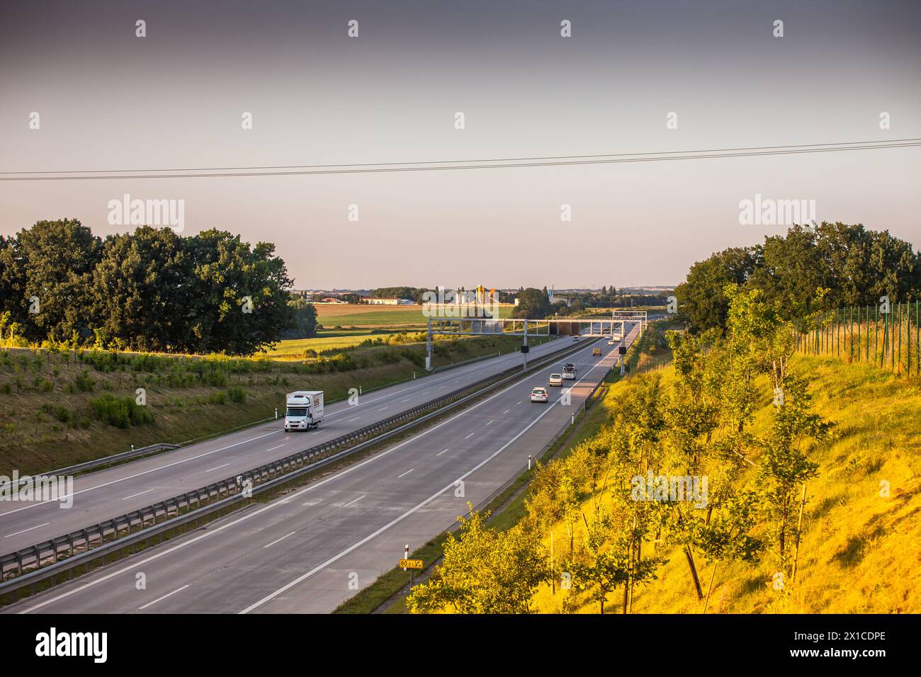 Coucher de soleil sur une autoroute tranquille en République tchèque, avec des véhicules en mouvement. Banque D'Images