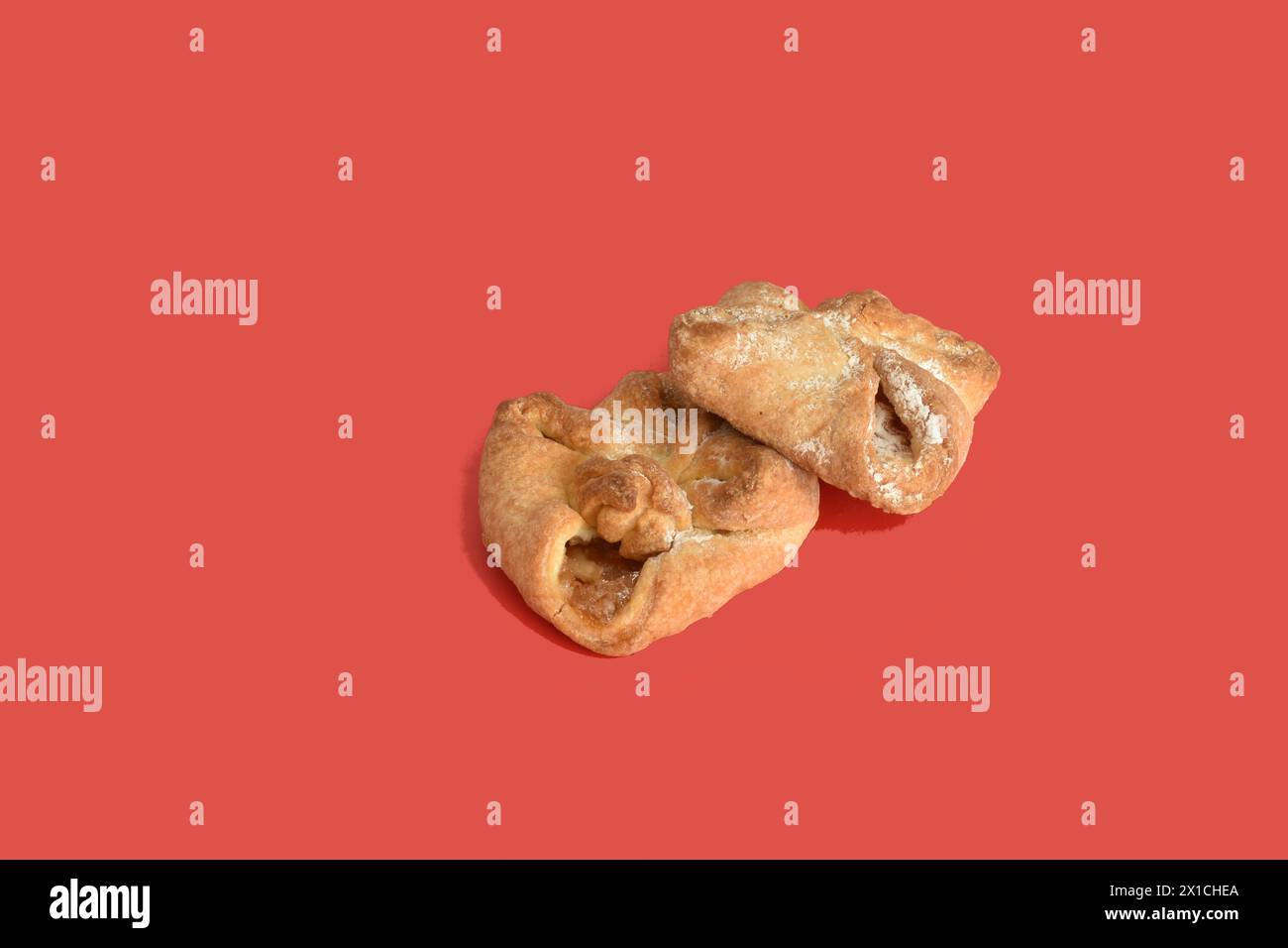 Plusieurs biscuits fourrés de forme carrée reposent sur un fond rouge. Banque D'Images