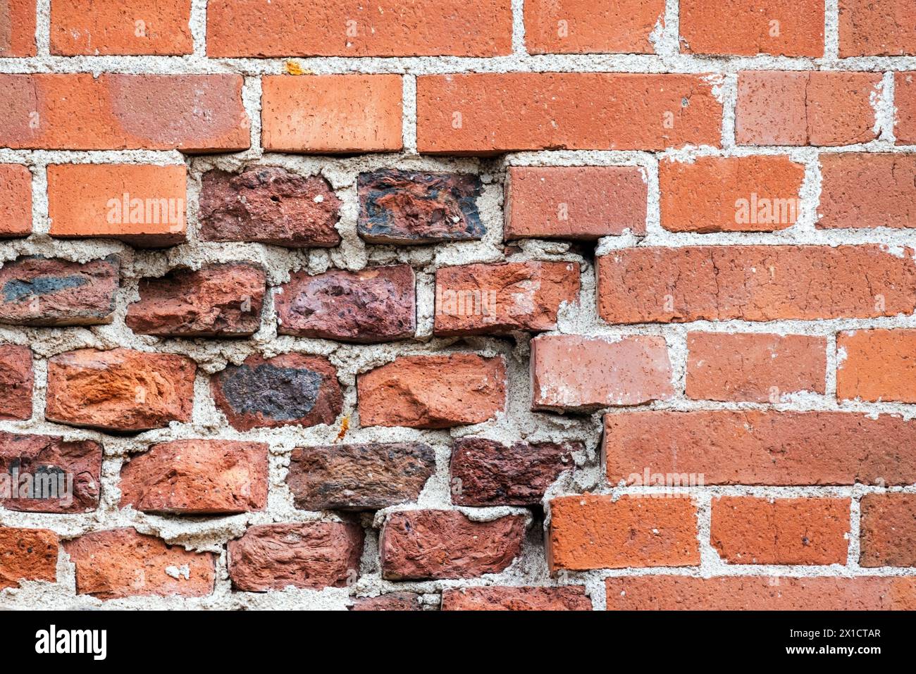 Mur de briques rouges endommagé avecold et nouvelles briques, texture de photo de fond Banque D'Images