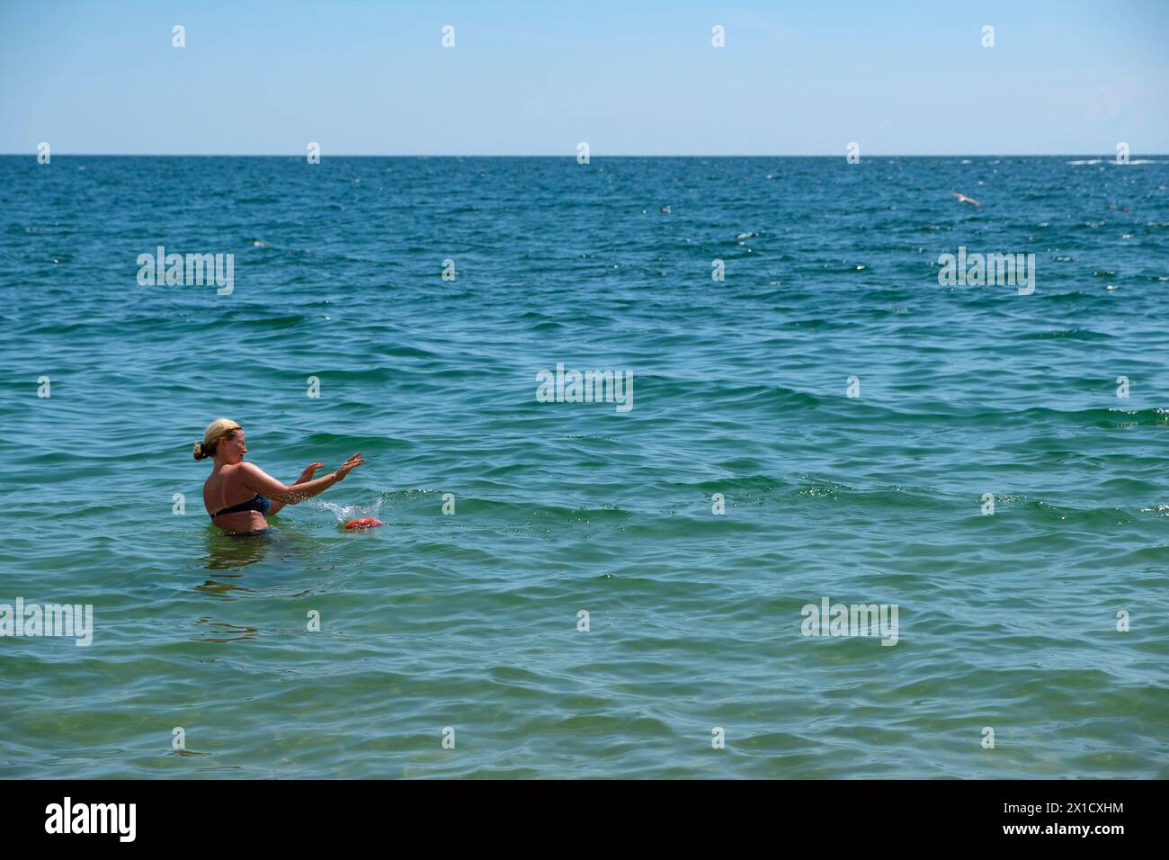 Femme jouant un jeu de balle dans la mer Noire à Varna Golden Sands Beach en Bulgarie. Banque D'Images