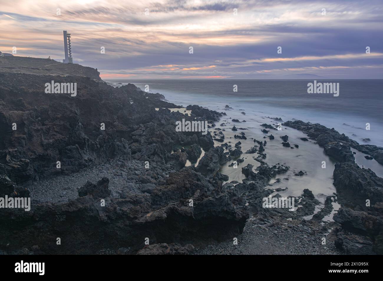 Paysage volcanique et océan avec le phare Buenavista, avec la dernière lumière du jour, juste avant la tombée de la nuit, Tenerife, îles Canaries Banque D'Images