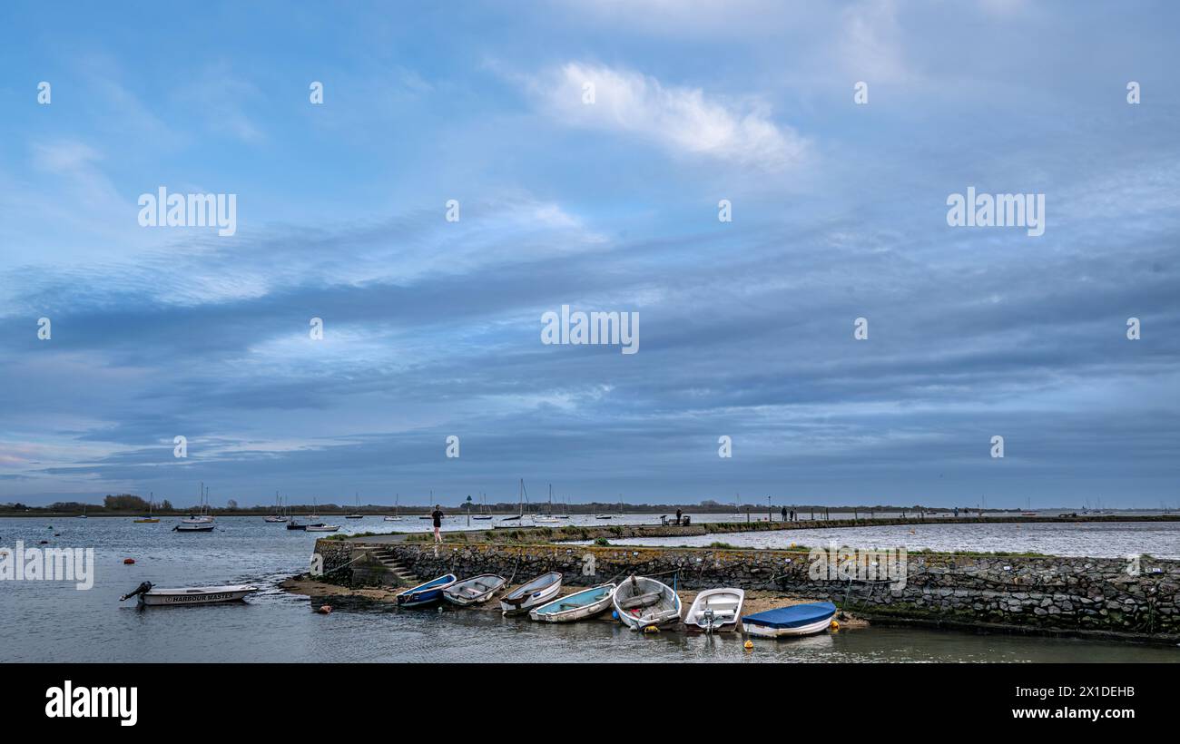 Bateaux à rames amarrés le long du mur du port et de la jetée d'une station de pêche et de plaisance anglaise. Banque D'Images