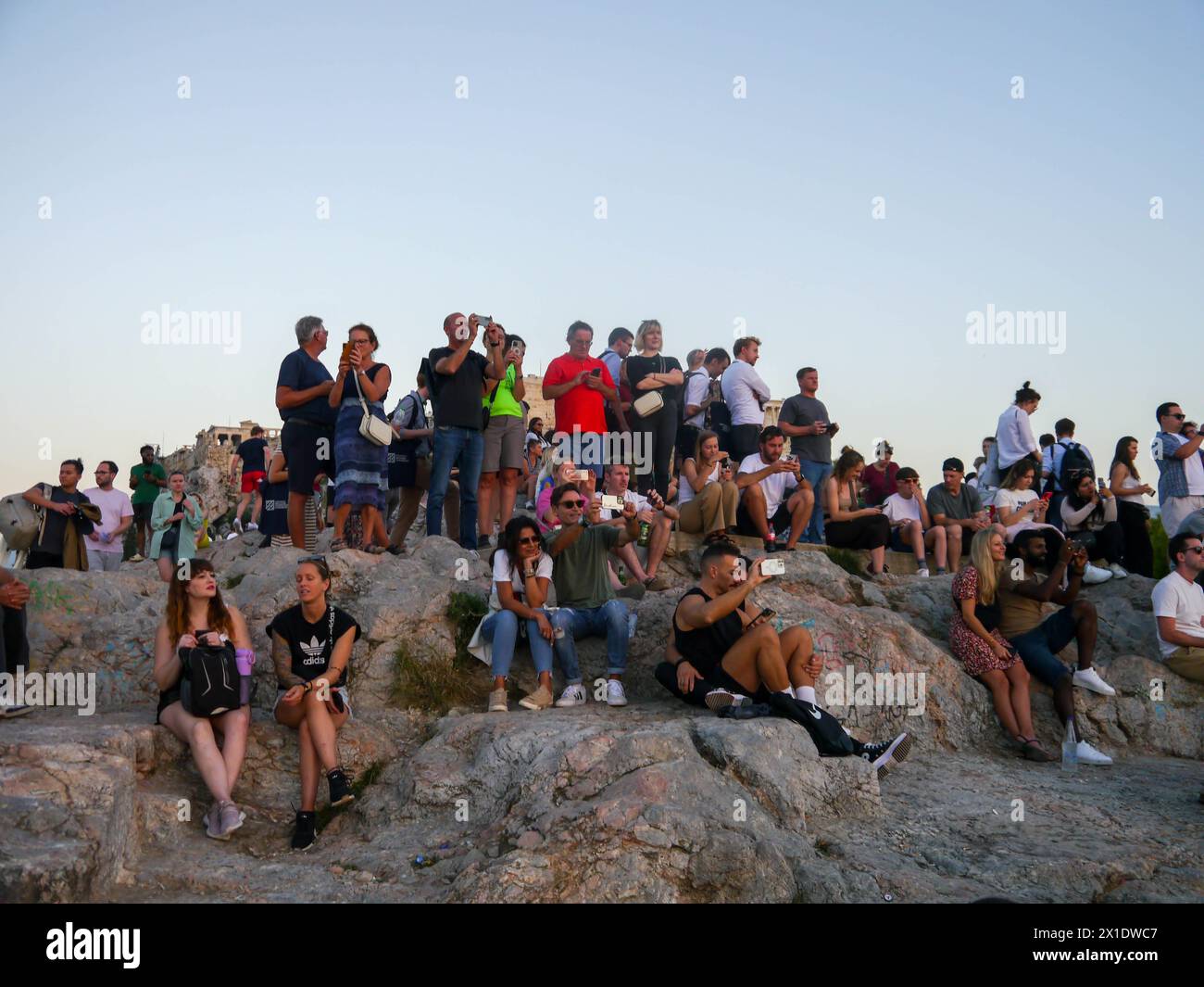 Les touristes se rassemblent pour regarder le coucher de soleil sur la colline d'Areopagus, Athènes, Grèce Banque D'Images
