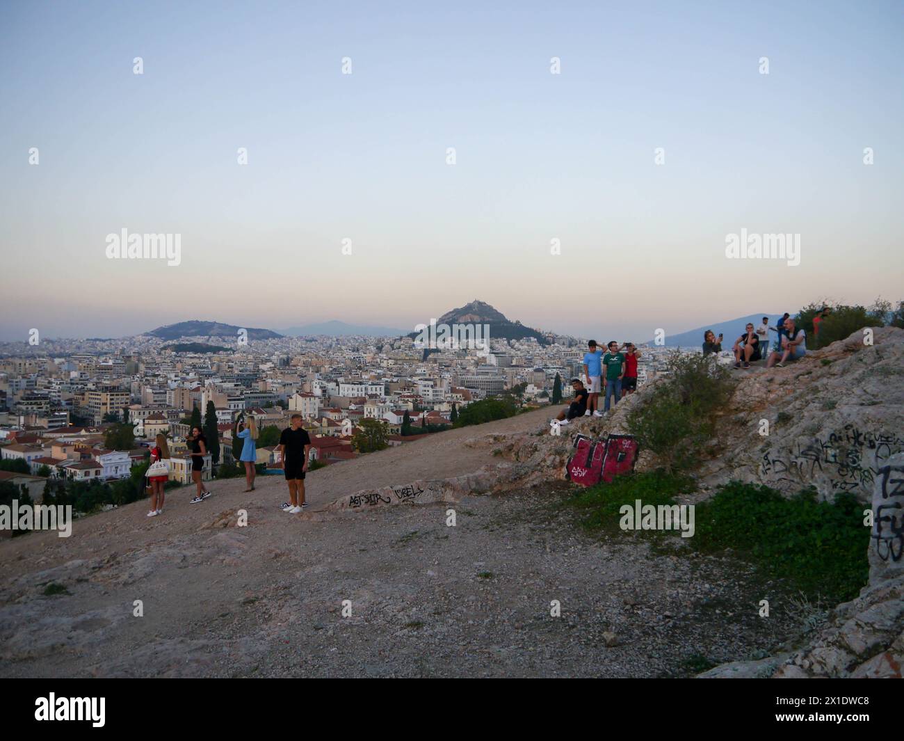 Les touristes se rassemblent pour regarder le coucher de soleil sur la colline d'Areopagus, Athènes, Grèce Banque D'Images