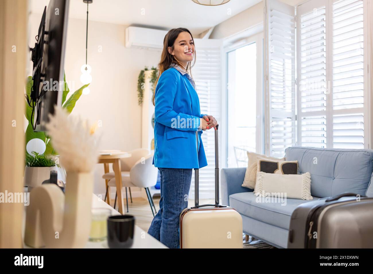 Jeune femme avec sa valise dans un appartement loué Banque D'Images