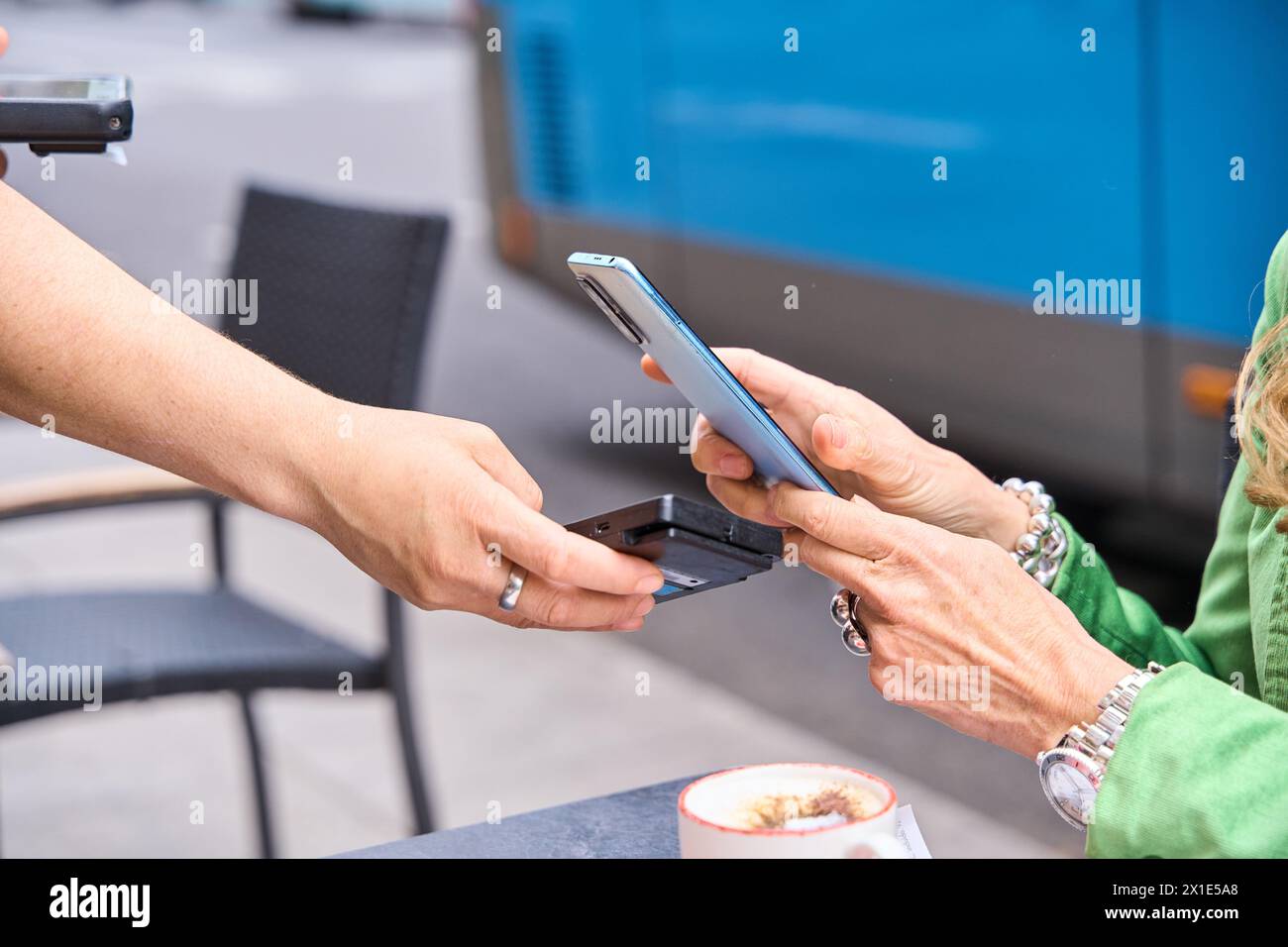 Femme payant la facture via son smartphone en utilisant la technologie NFC dans un restaurant. Gros plan mains de paiement mobile dans un café Banque D'Images