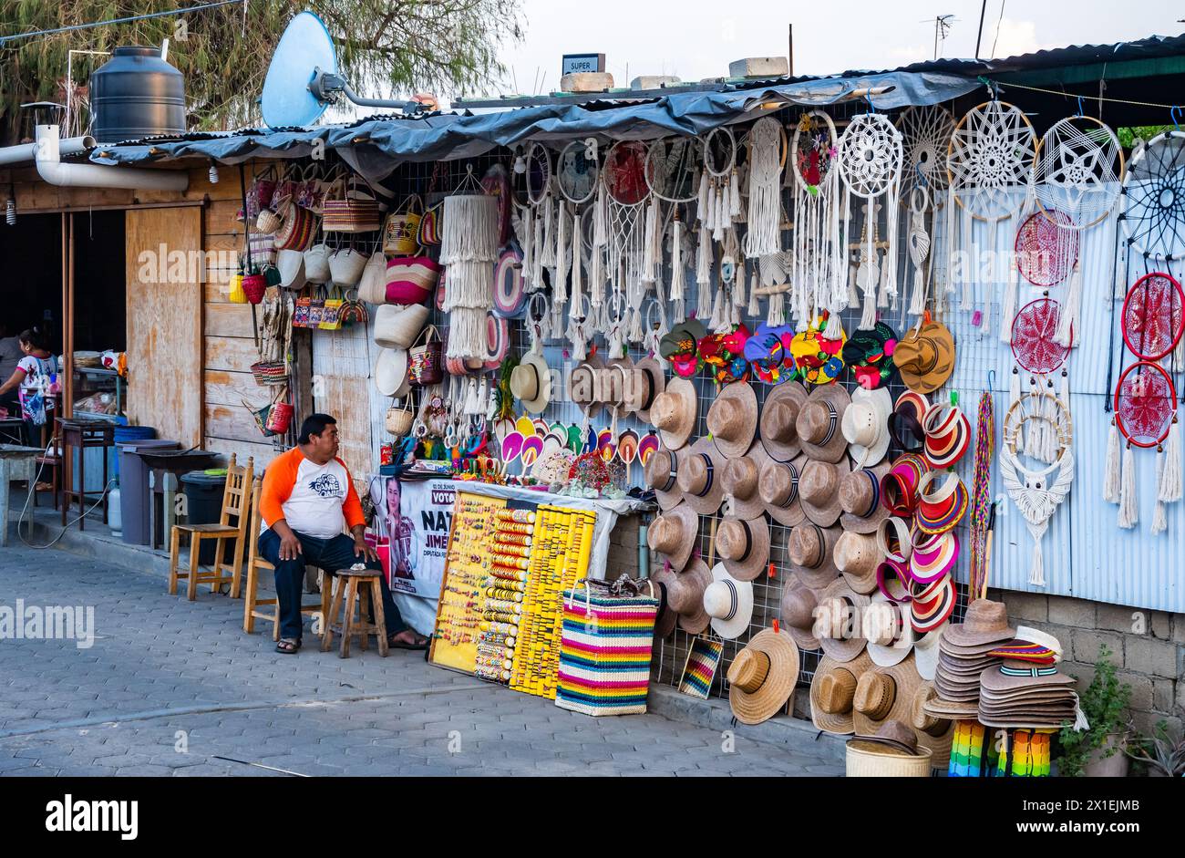 Un homme vendant des chapeaux et des sacs tissés, ainsi que d'autres produits locaux. Oaxaca, Mexique. Banque D'Images