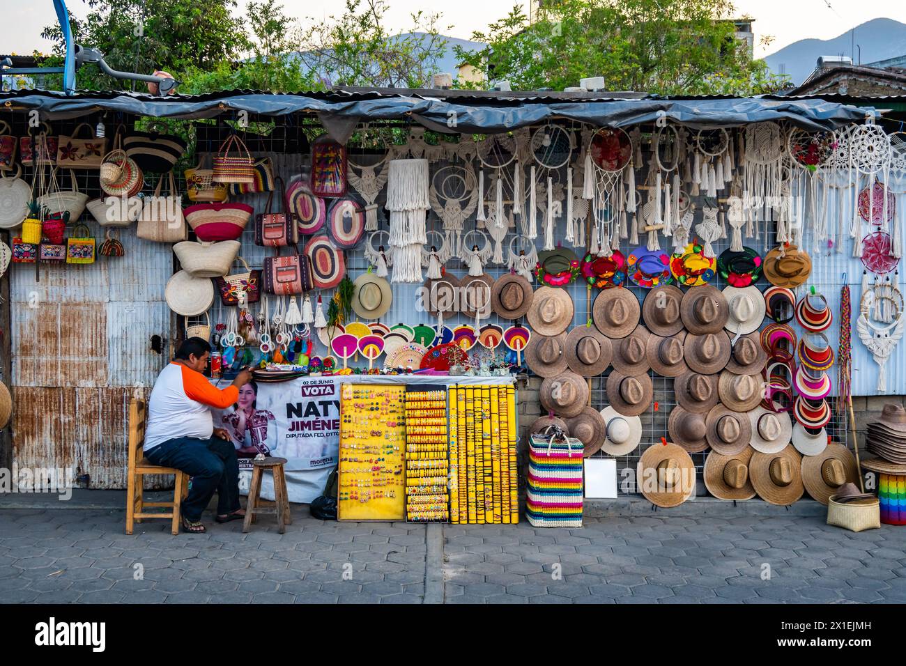 Un homme vendant des chapeaux et des sacs tissés, ainsi que d'autres produits locaux. Oaxaca, Mexique. Banque D'Images