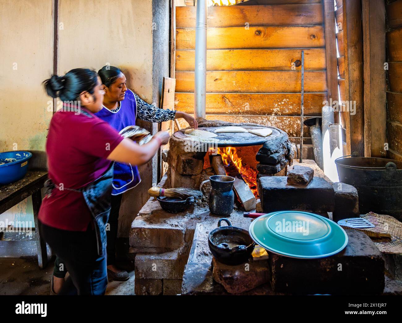 deux femmes cuisinant une tortilla de maïs sur un poêle plat traditionnel. Oaxaca, Mexique. Banque D'Images