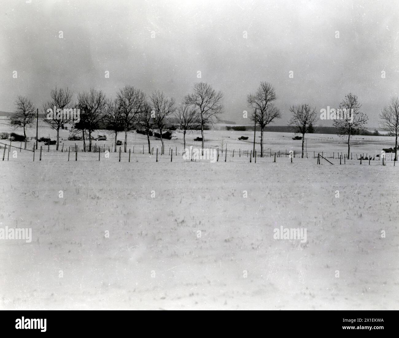 Photos de la seconde Guerre mondiale : légende originale : « les forces blindées du général Patton qui ont relevé 101 hommes aéroportés qui ont tenu Bastogne pendant dix jours, commencent leur route au-delà de Bastogne. Un obus d'artillerie allemand peut être vu exploser au centre de la photo.' env. Décembre 1944 Banque D'Images