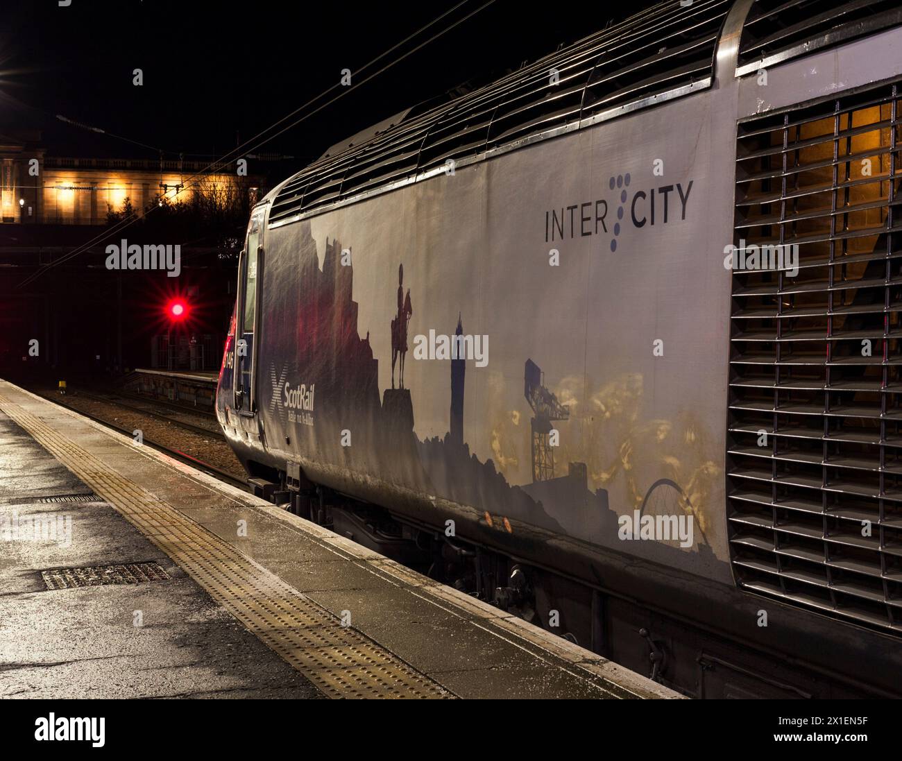 Train ScotRail Inter7City attendant à la gare de Waverley d'Édimbourg dans l'obscurité tôt le matin avec des signaux de danger rouges Banque D'Images