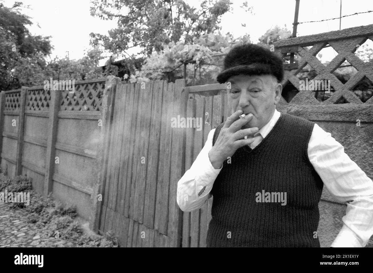 Bucarest, Roumanie, 1990. Homme fumant une cigarette devant sa maison dans le quartier de Ferentari. Banque D'Images