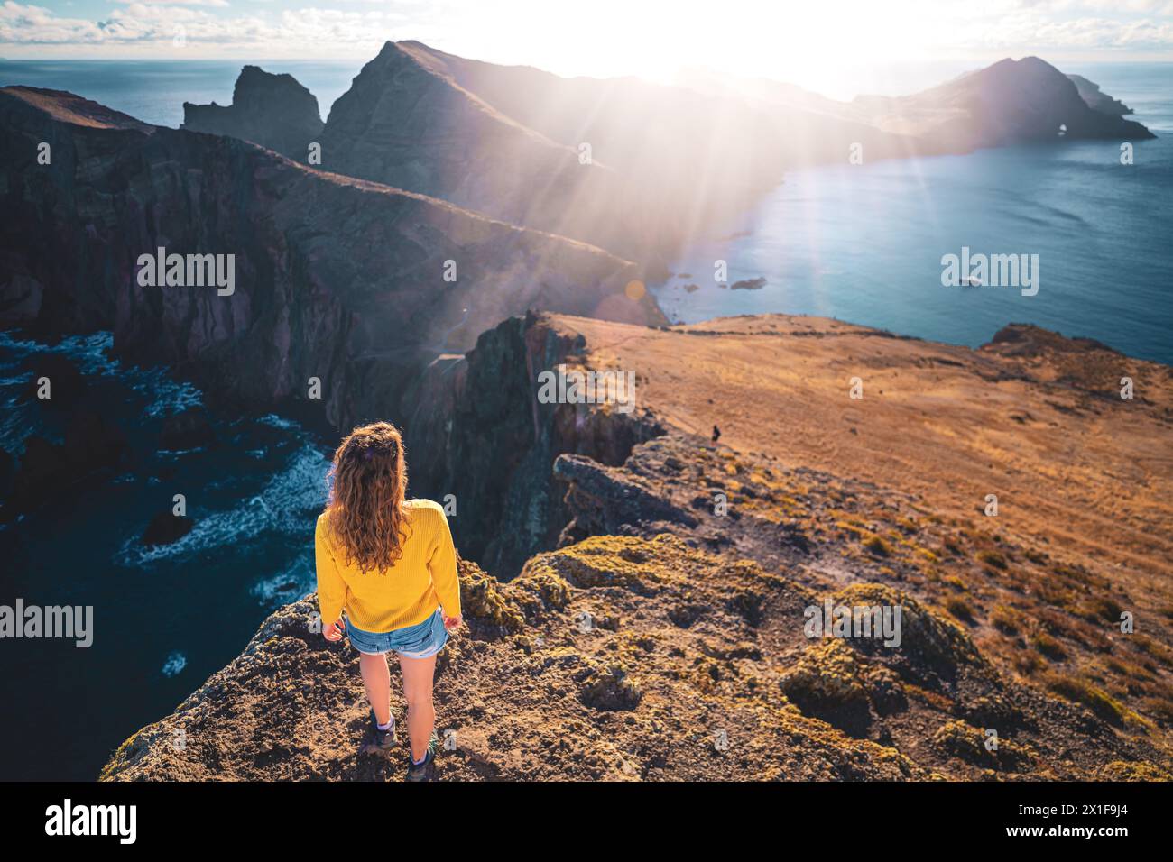 Description : vue de dessus d'une femme regardant les contreforts d'une île volcanique dans l'océan Atlantique depuis un point de vue panoramique matinal. São Lou Banque D'Images