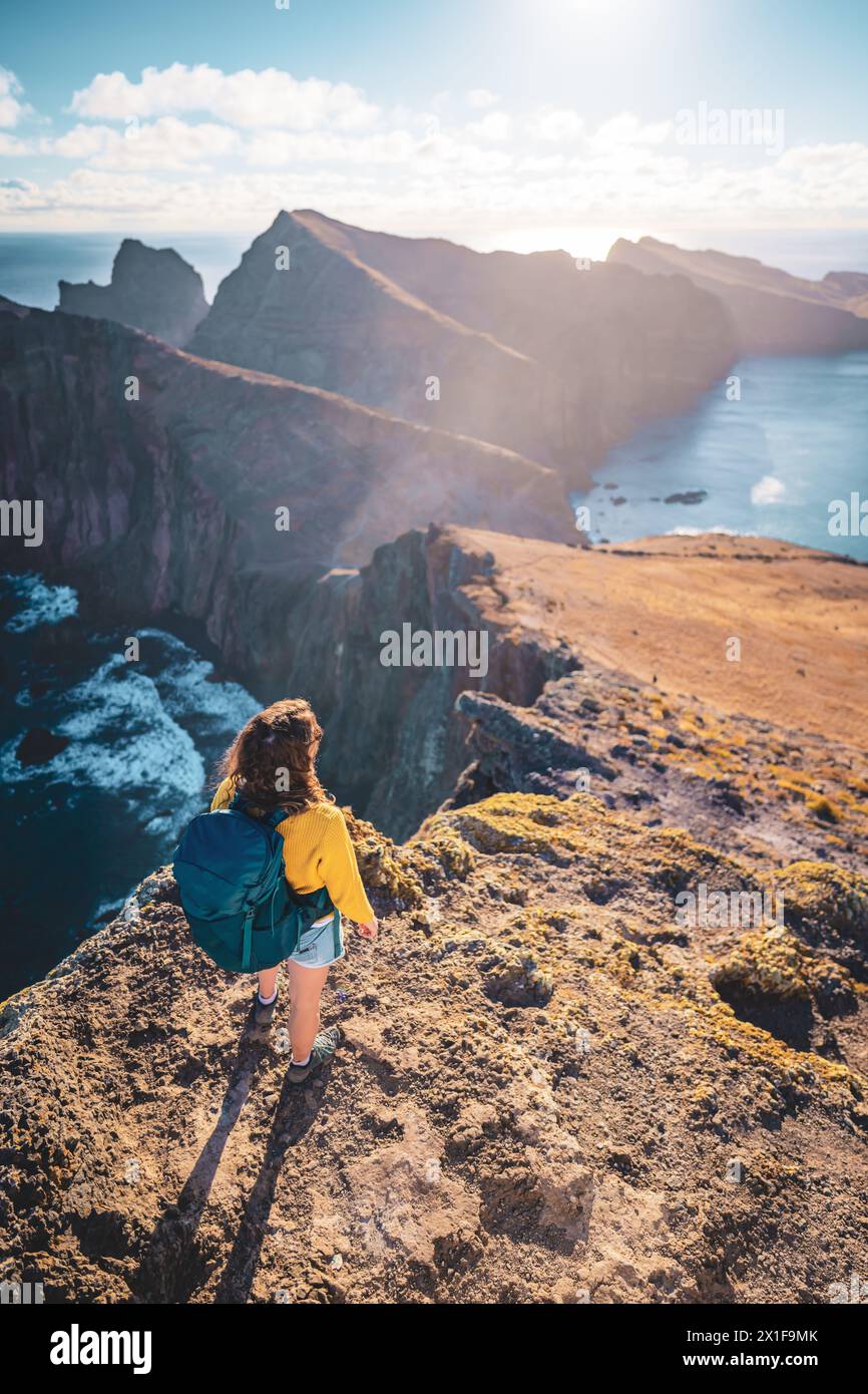 Description : vue de dessus d'une femme routard regardant d'une vue panoramique matinale sur les contreforts d'une île dans l'océan Atlantique. São Louren Banque D'Images